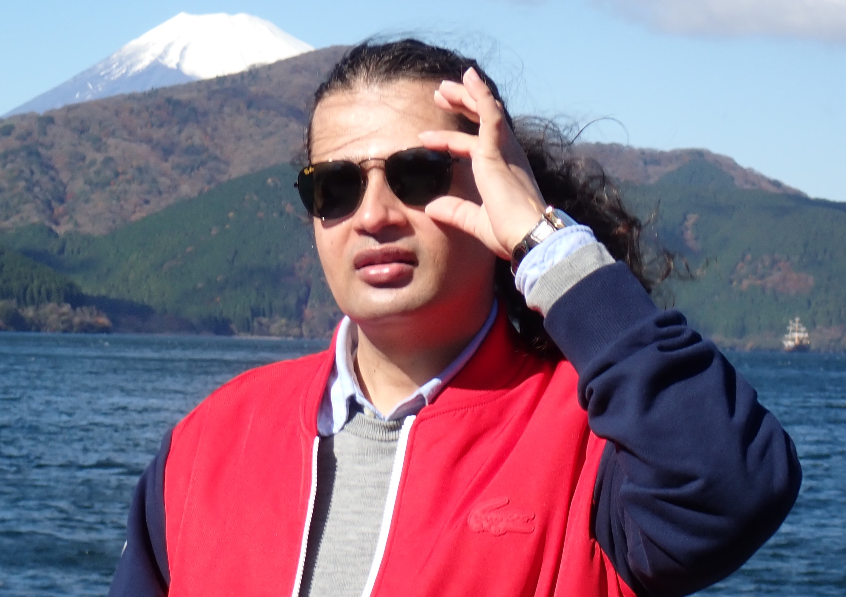 Dr. Ram C. Sharma wearing sunglasses with Mount Fuji in the background.