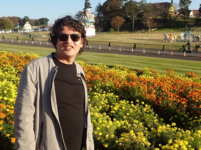 Dr. Ram C. Sharma wearing sunglasses in a colorful flower garden.