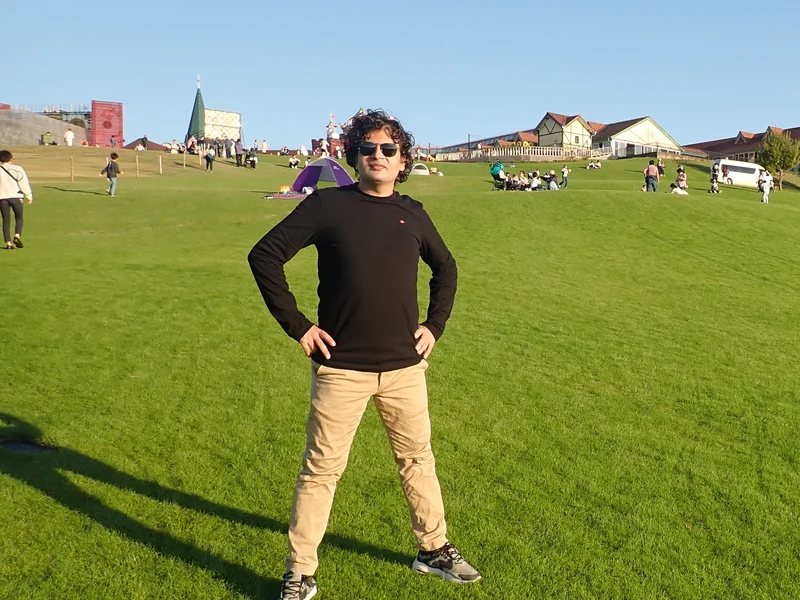 Dr. Ram C. Sharma wearing sunglasses while standing on a broad green lawn.